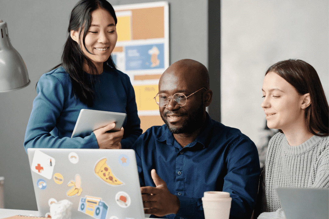 Screenshot showing a happy team of co-workers with a computer